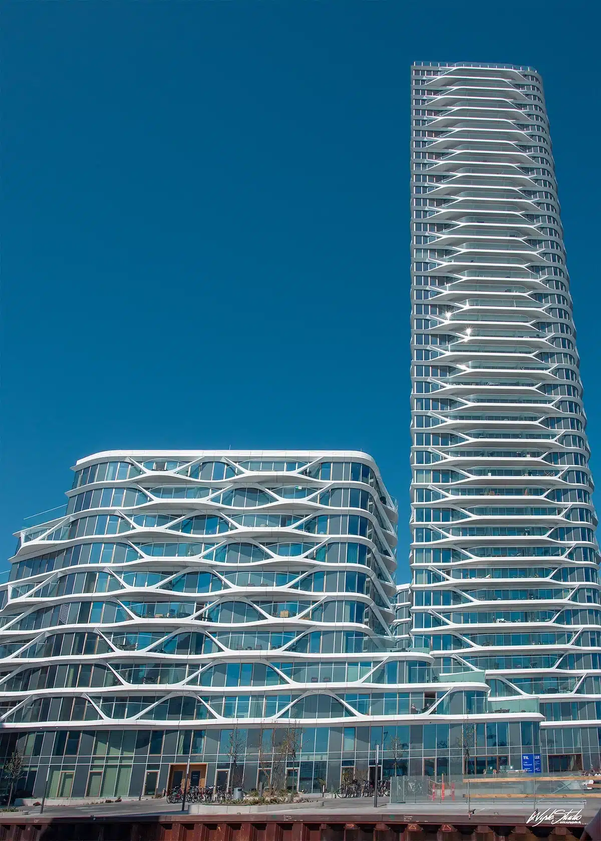 Facade på Lighthouse i Aarhus med det ikoniske bølgende hvide gitterdesign og glaspartier.