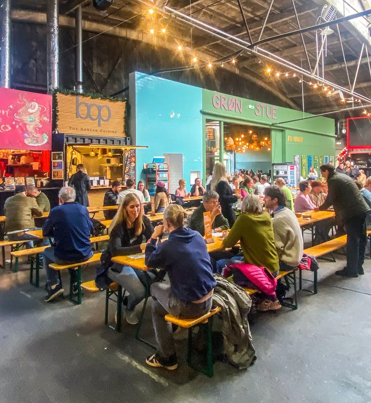 Gæster spiser ved langborde i Aarhus Street Food