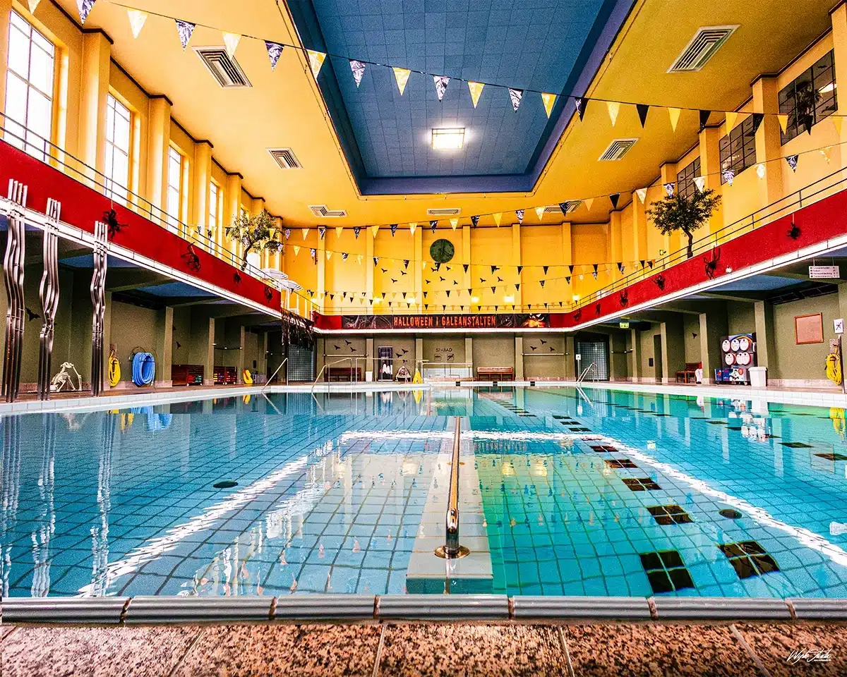 Svømmehallen i Badeanstalten Spanien med høje vinduer og blå vandflade