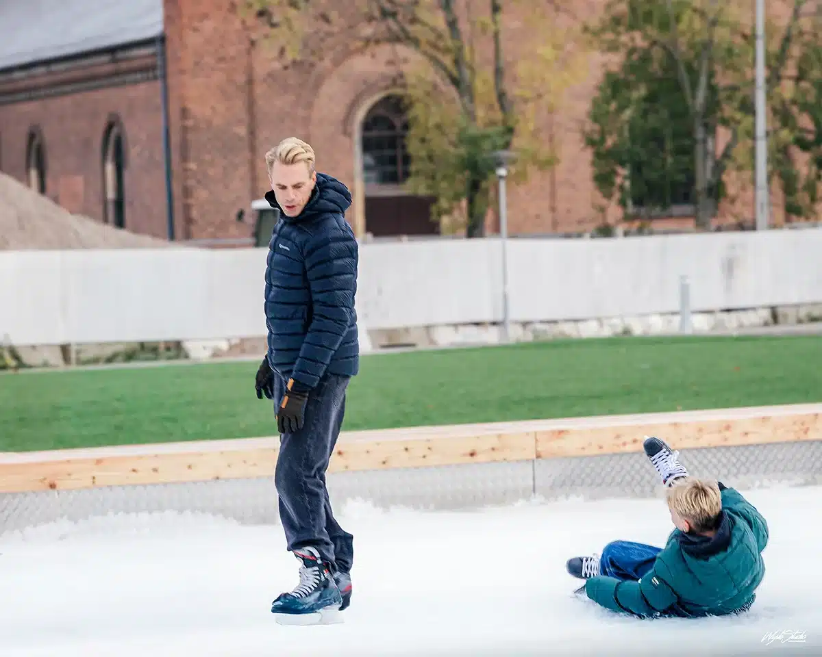 Far og søn på isen, hvor sønnen falder, på Skøjtebanen Musikhusparken