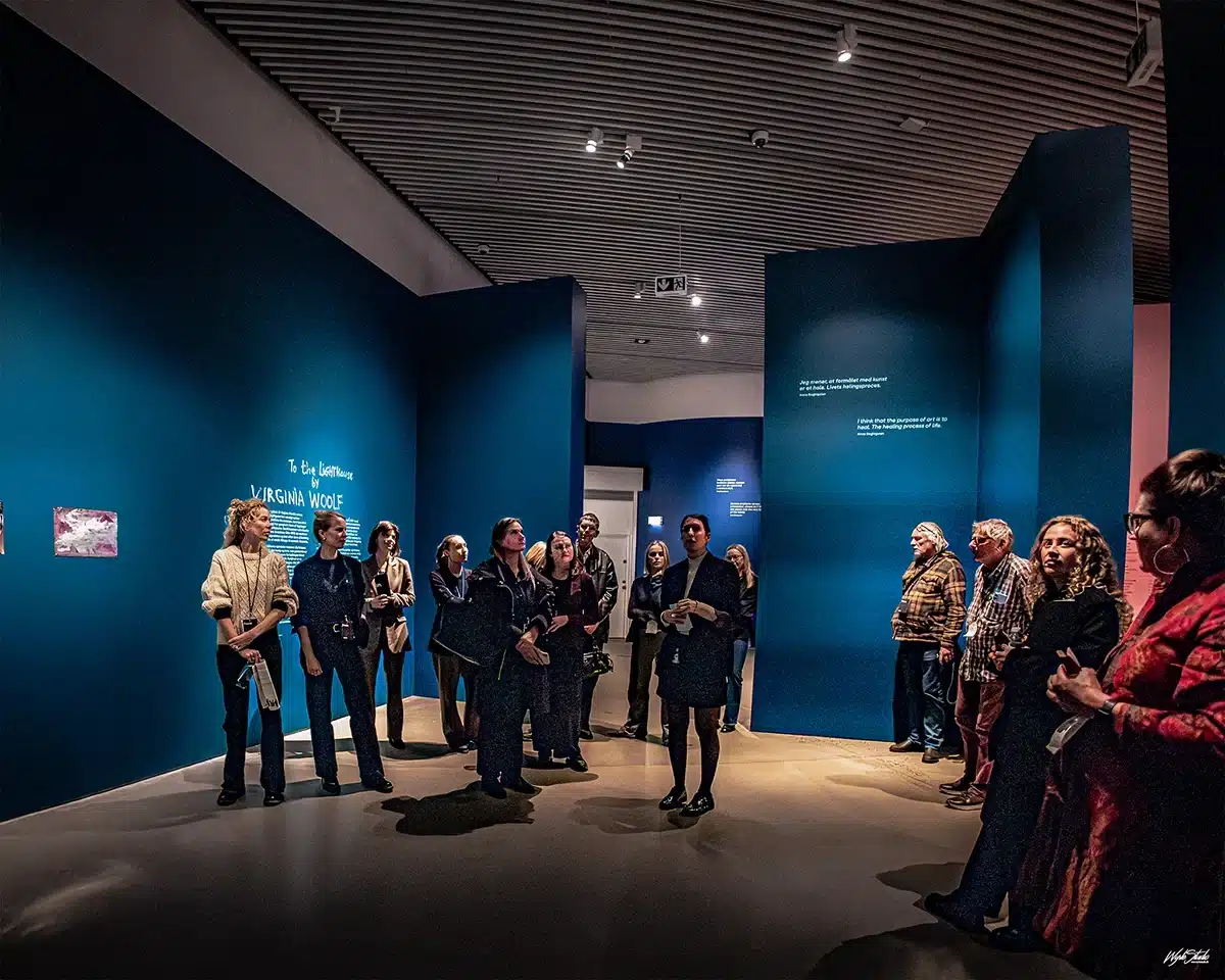 Gæster samlet foran det første rum i Anna Boghiguians udstilling på ARoS, badet i den dybe blå farve fra To the Lighthouse