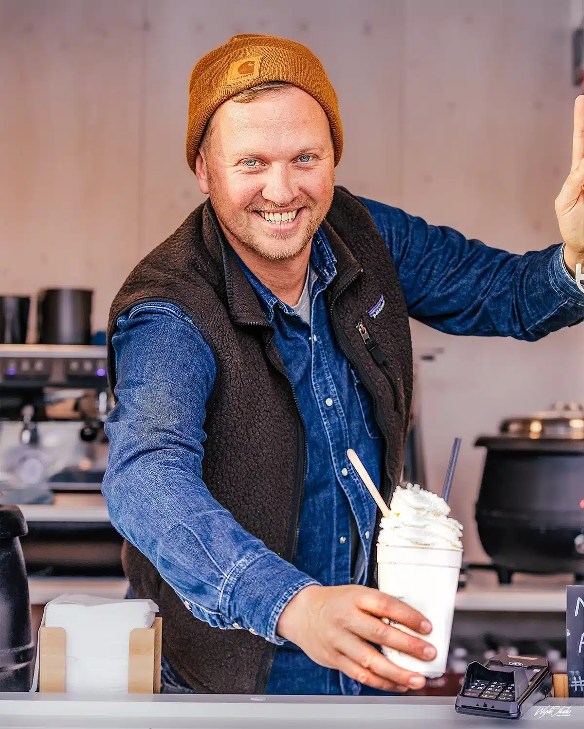 Mand smiler og serverer varm kakao i kiosken ved Skøjtebanen Musikhusparken