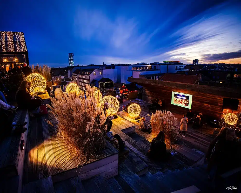 Platform i Salling Christmas Garden med julepyntet træ og udsigt til ARoS’ regnbue i baggrunden.