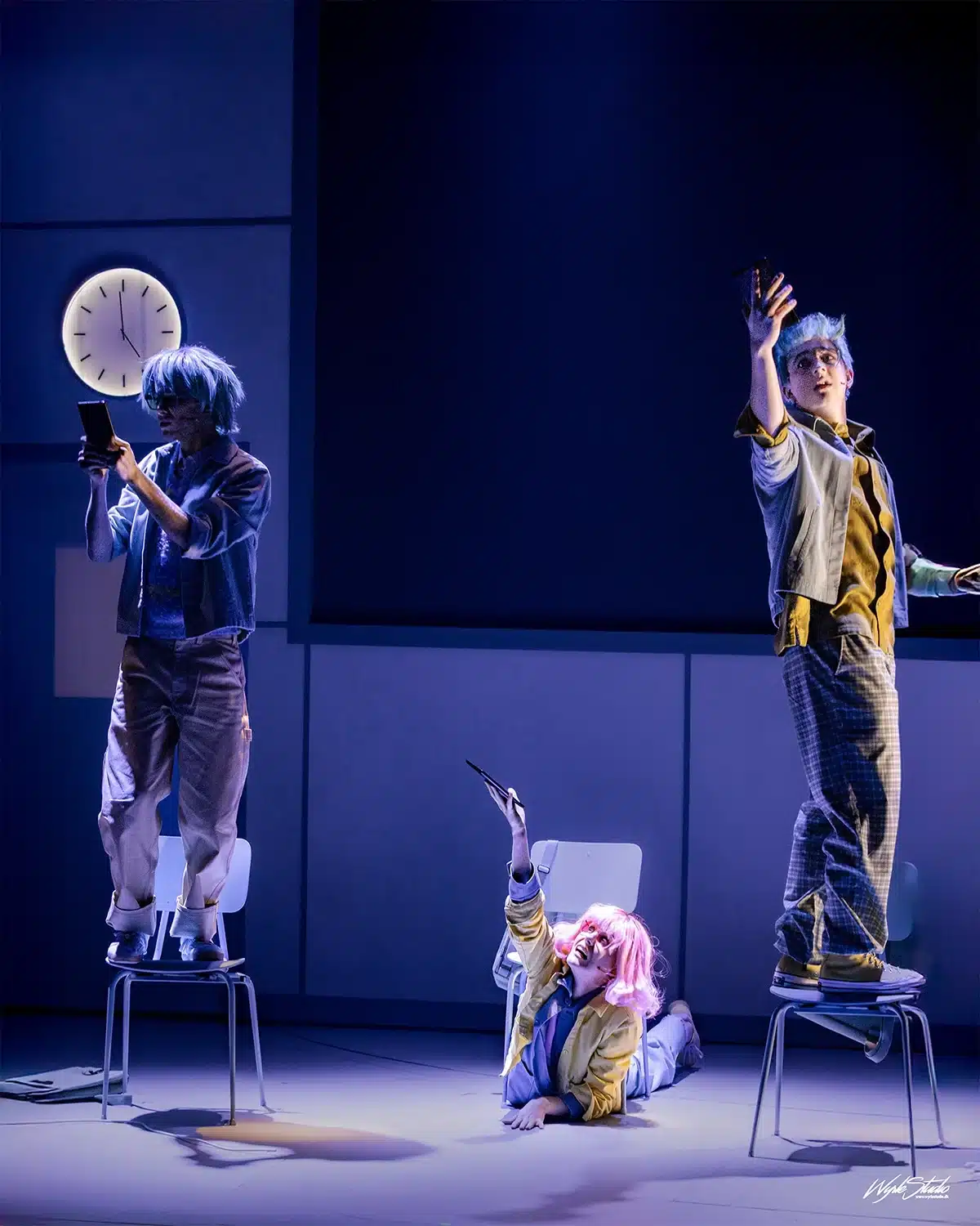 Skuespillere i Julen findes ikke på Aarhus Teater står og ligger på stole med mobiltelefoner