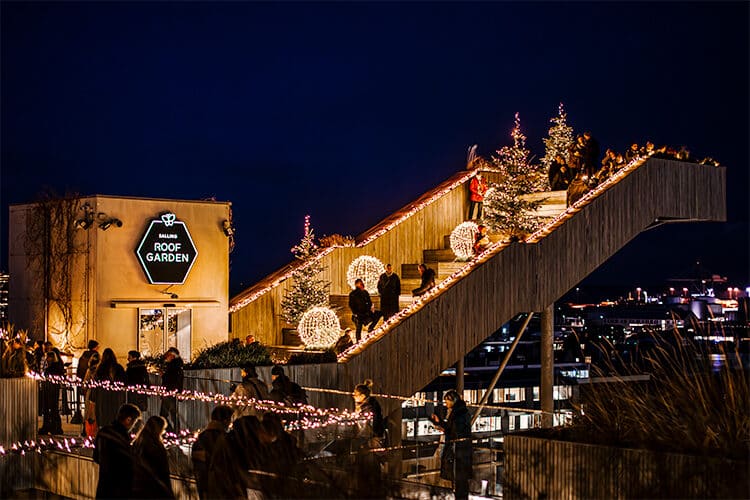 Trappen i Salling Christmas Garden pyntet med juletraeer og store lysende kugler mens gaester gaar op og ned » Aarhus Inside Salling Christmas Garden åbner – Aarhus får sit eget vintereventyr i højden