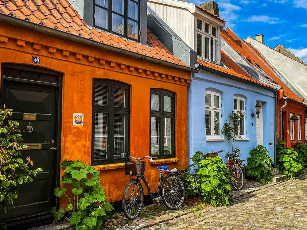 En parkeret cykel foran et flot orange hus på Møllestien