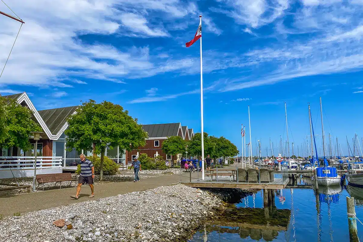 Flag og både ved Egå Marina med gående gæster