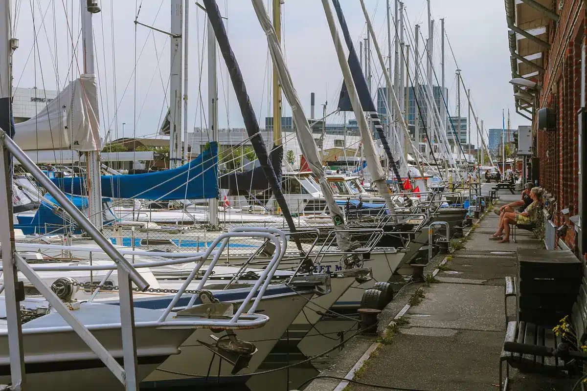 Sejlbåde langs kajen ved murstensbygning i Aarhus Lystbådehavn