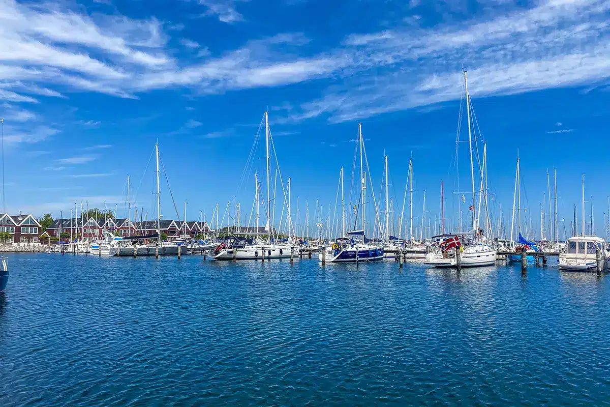 Sejlbåde og røde huse ved Egå Marina i solskin