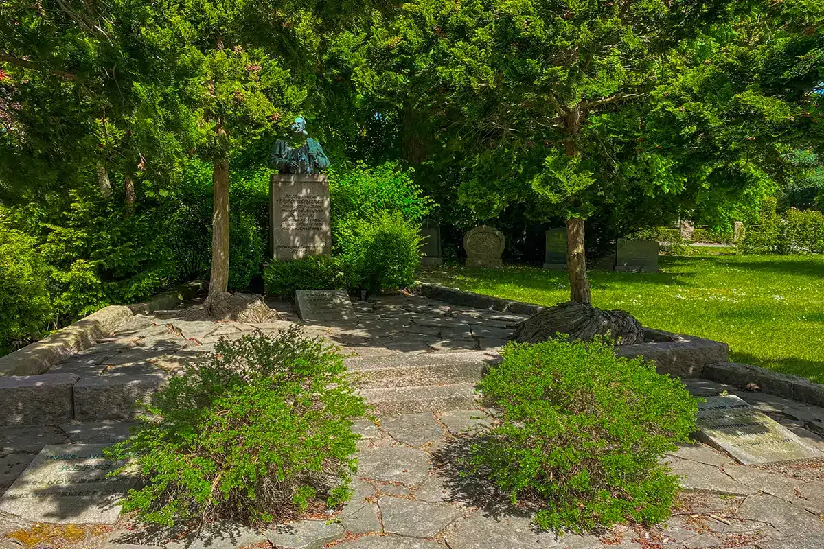 Statue omgivet af ro og grønt på Nordre Kirkegård