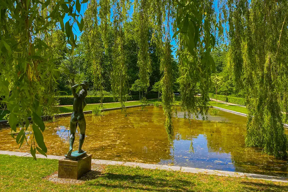 En skulptur ved det spejlende vand i den smukke Mindeparken