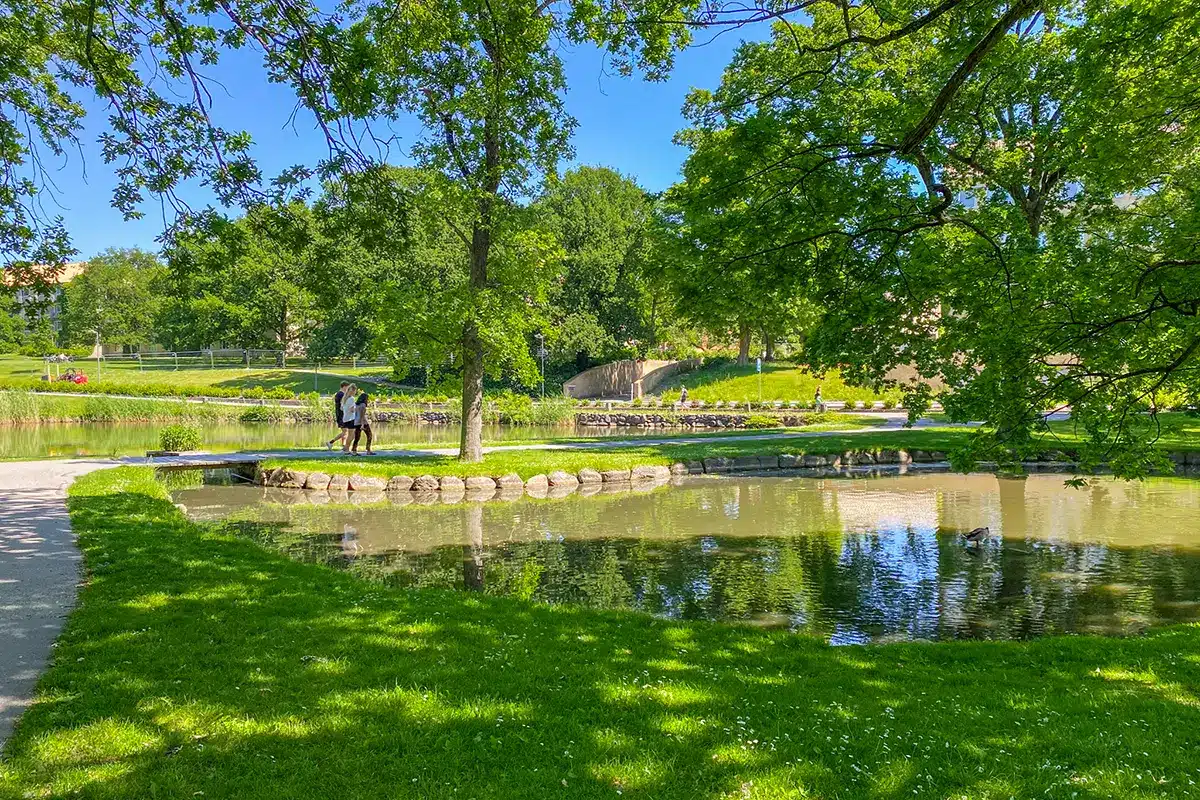 Gangbro over søen i Universitetsparken med mennesker