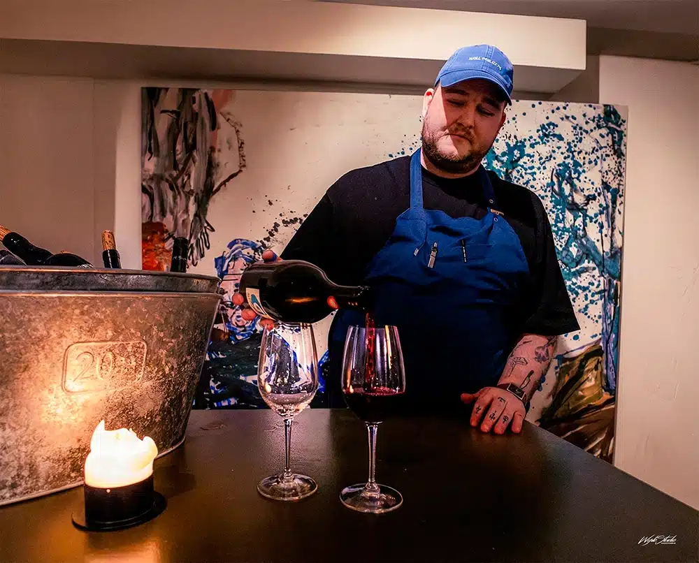 Sommelier Emil skænker rødvin til gæsterne hos Restaurant Møf