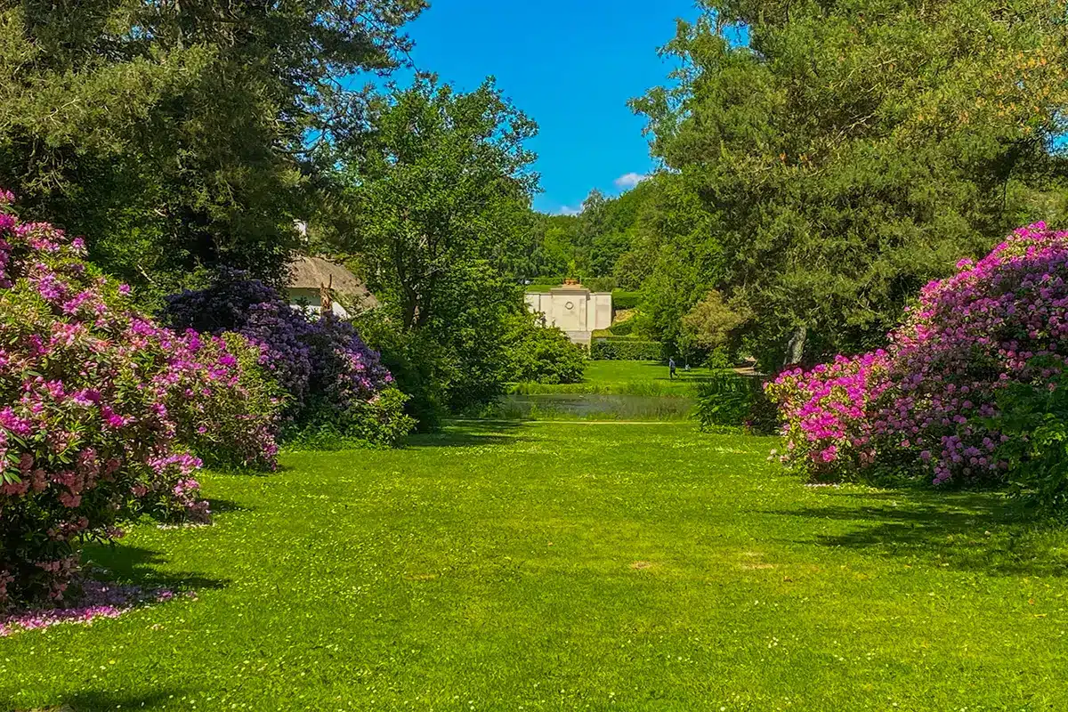 Udsigt gennem blomstrende buske mod det historiske monument i Mindeparken