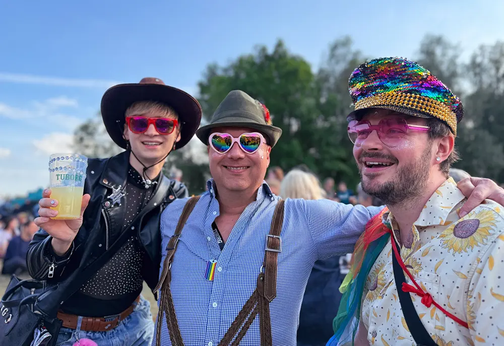 Tre festivalgæster i farverige outfits og solbriller på NorthSide 2026 lørdag