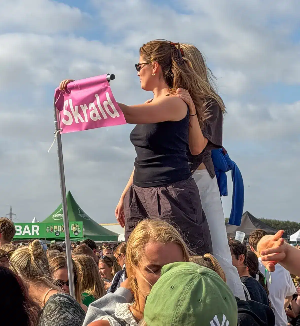 Festivalgæster foran et skilt med teksten skrald