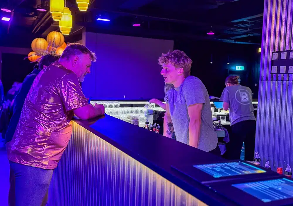 Bartender betjener en gæst ved baren i The Ballroom