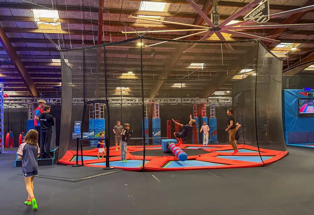 Børn og voksne spiller dodgeball på trampoliner i RUSH