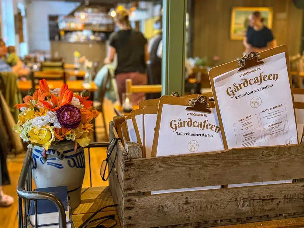 Menukort og blomster ved indgangen til GårdCafeen i Latinerkvarteret