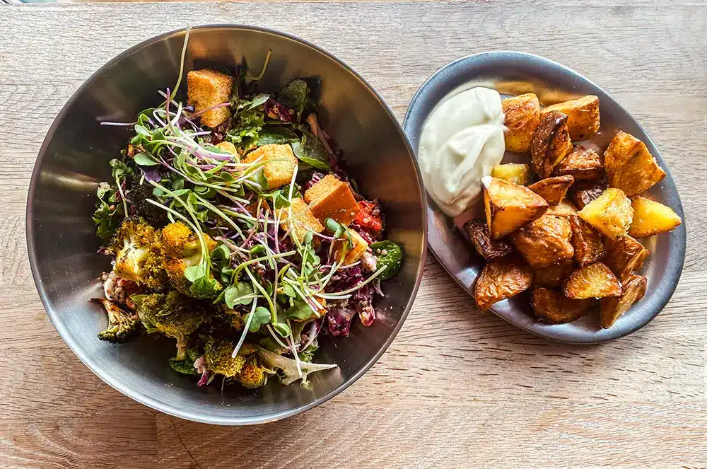 Cajun broccolisalat med spirer, rødkål og croutoner ved siden af ovnstegte kartofler med hjemmerørt mayo på Plant Food