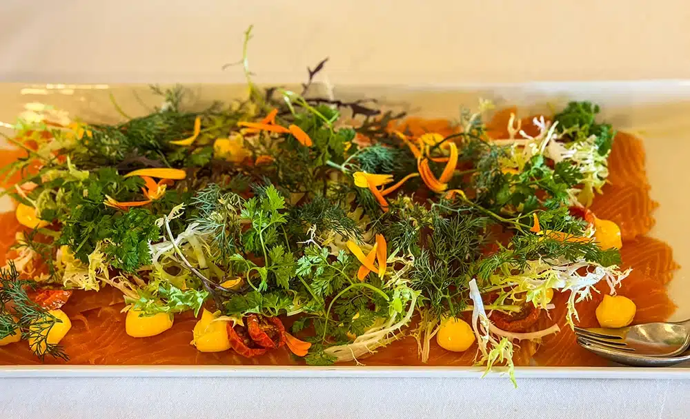 Laks med dild, kørvel, frisésalat og spiselige blomster på brunchbuffeten på Varna Palæet