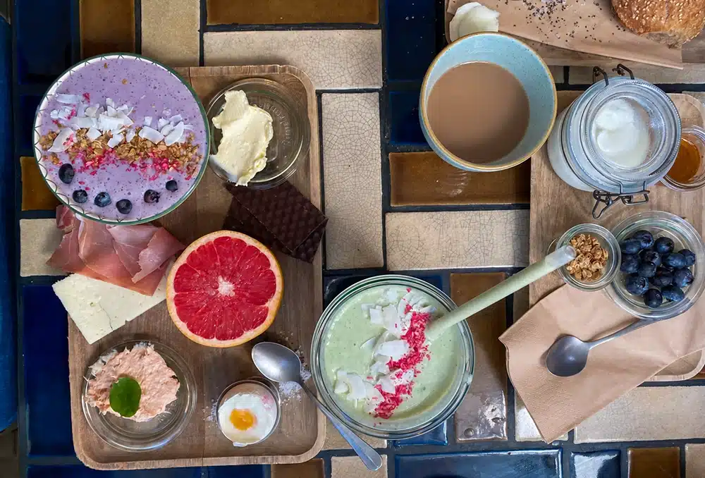 brunchbræt hos OS Kaffe & Vin med smoothie bowls, frisk frugt, ost, pålæg og kaffe.